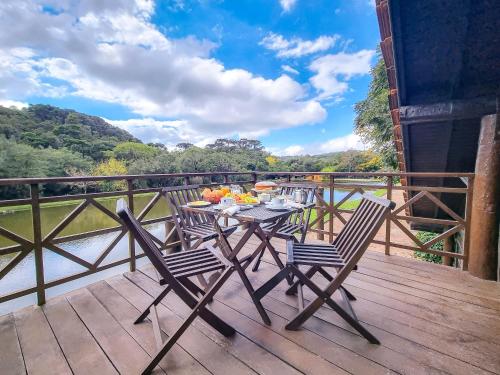 a table and chairs on a deck with a view at Hotel La Dolce Vita in Tijucas do Sul