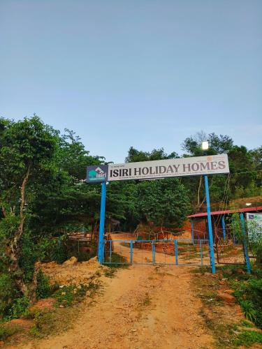 a sign that reads festival holiday homes next to a dirt road at Isiri river side stay in Kalasa