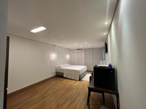 a bedroom with a bed and a tv in it at Ziza Hospedagem in Maringá