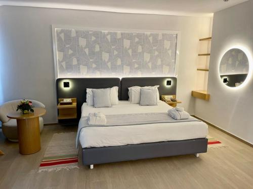 a bedroom with a bed with a large headboard at Royal Tulip Taj Sultan in Hammamet