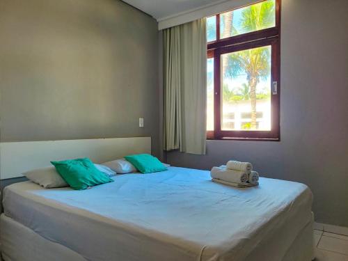 a bedroom with a large bed with a window at Maraca Beach Beira-mar in Porto De Galinhas