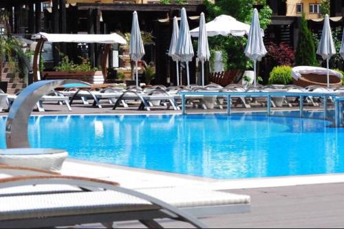 a swimming pool with chairs and umbrellas at Militari Residence Luxury 23 in Roşu