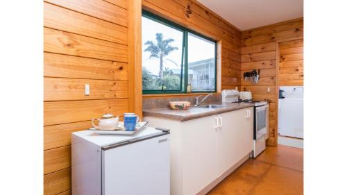 a kitchen with wooden walls and a window at Wine Downtime - Mangawhai Holiday Home in Mangawhai