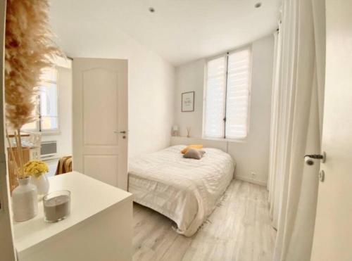 une chambre blanche avec un lit et une fenêtre dans l'établissement Joli appartement au calme à 10 min à pied des Marches et des plages, à Cannes
