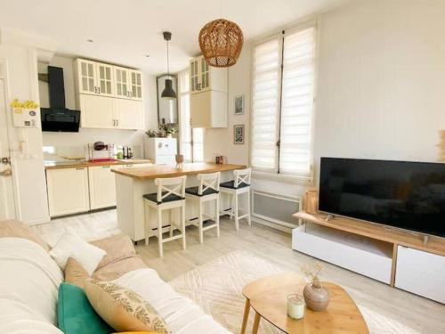 un salon avec un canapé et une cuisine dans l'établissement Joli appartement au calme à 10 min à pied des Marches et des plages, à Cannes