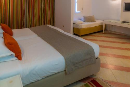 a hotel room with a large bed and a couch at Royal Tulip Taj Sultan in Hammamet