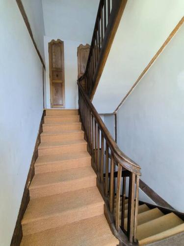 a wooden staircase with a wooden door in a house at Maison exceptionnelle le Peyret -Vue Pyrenées-Jardin-Piscine in Serres-Castet