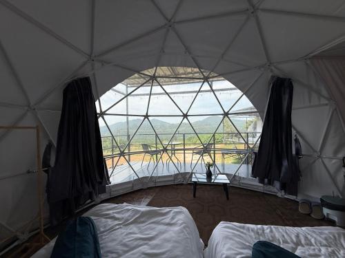 a room with a large window in a tent at บ้านเชิงเขา โฮมสเตย์ in Ban Mai