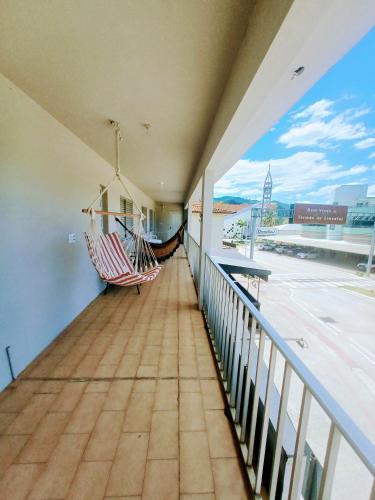 a balcony with two hammocks and a view of a street at Apartamento vista montanha in Gravatal