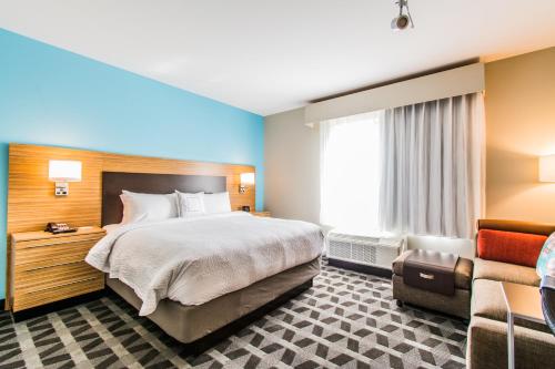 a hotel room with a bed and a couch at TownePlace Suites by Marriott Evansville Newburgh in Newburgh