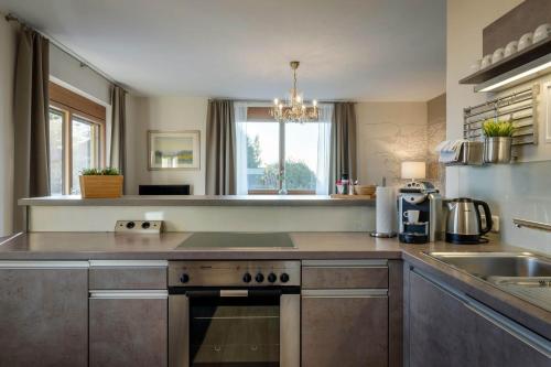 a kitchen with a stove top oven next to a sink at WURZENBERG Hotel Lodges Südsteiermark in Gamlitz