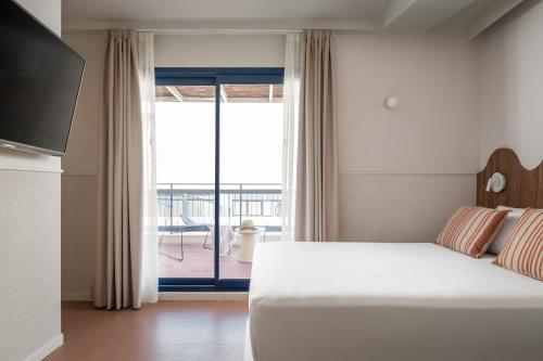 a bedroom with a bed and a sliding glass door at BYPILLOW Paseo in Alicante