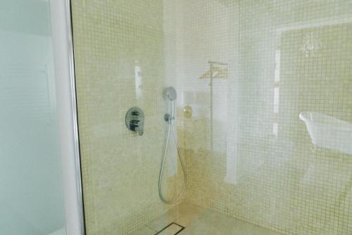 a shower with a glass door in a bathroom at Spacious seaside house in Cascais