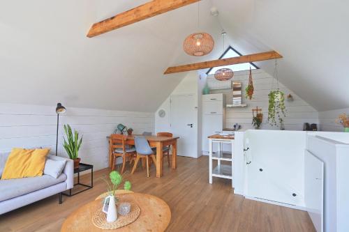 a kitchen and living room with a couch and a table at NIEUW! Vakantiehuis Singel 3A met SAUNA - baddomburg in Domburg