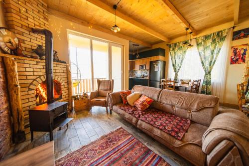 a living room with a couch and a fireplace at Happy days house in Shuakhevi