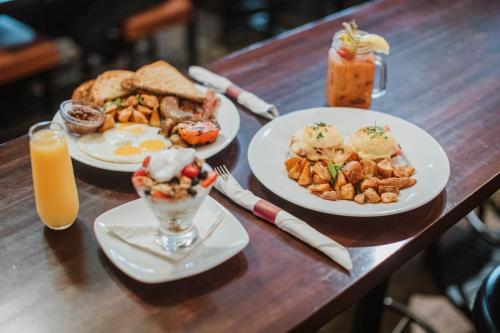 a wooden table with plates of breakfast food and drinks at Club Quarters Hotel Central Loop, Chicago in Chicago