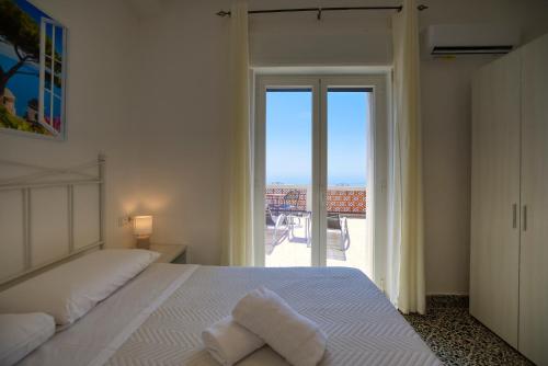a bedroom with a bed with a view of the ocean at Villa Pino in Furore