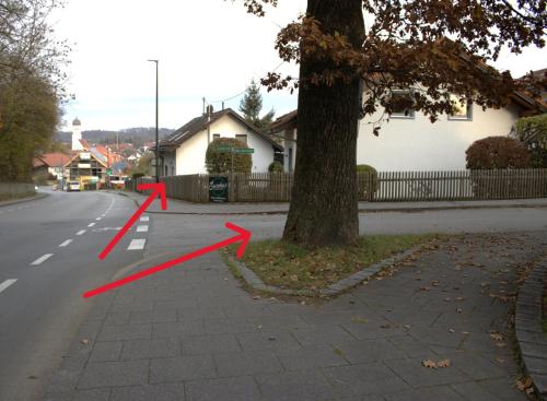 a street with red arrows on the side of a tree at Traumhafte Ferienwohnung Andechs in Andechs