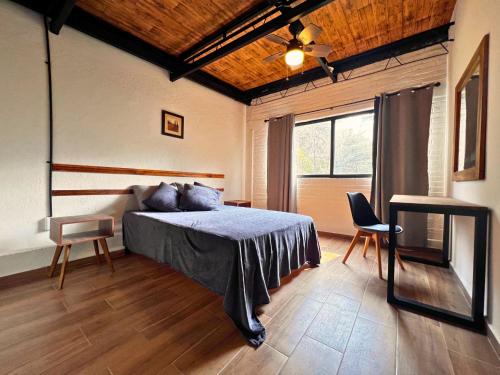 a bedroom with a bed and a table and a window at Discover Condesa Ideal Location in Mexico City