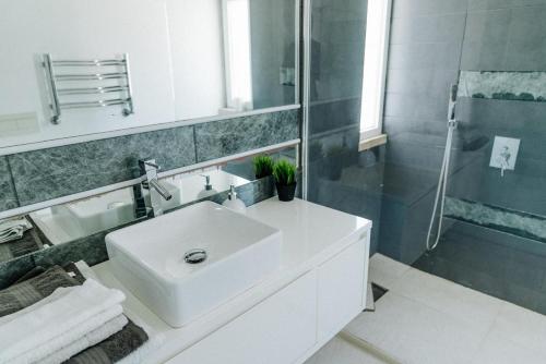 a white bathroom with a sink and a shower at Spacious seaside house in Cascais