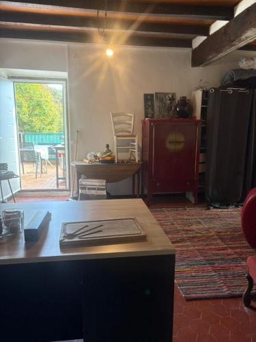 un salon avec une table et une cuisine avec une fenêtre dans l'établissement Maison de village, à Zevaco