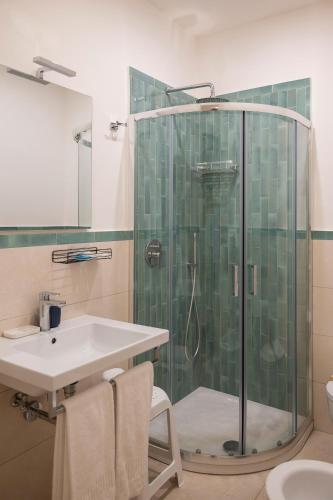 a bathroom with a glass shower and a sink at Villa Pino in Furore
