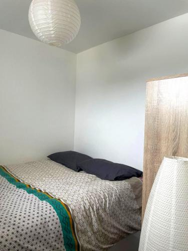 une chambre avec un lit et un mur blanc dans l'établissement Le Glaz et Ocre, à Quiberon