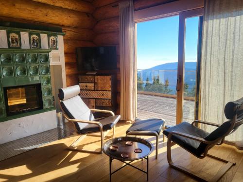 a living room with chairs and a fireplace with a view at KlippitzStar mit Panoramablick in Klippitztorl