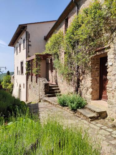 an old stone house with stairs leading to a door at Il Ginepro Home in Rosennano
