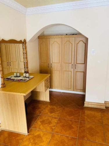 a kitchen with a wooden desk and wooden cabinets at THE HAVEN GUEST HOUSE NKOYOYO in Mbabane