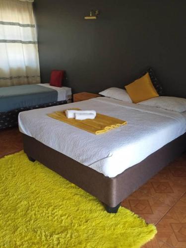 a bed with a blanket and a towel on it at THE HAVEN GUEST HOUSE NKOYOYO in Mbabane