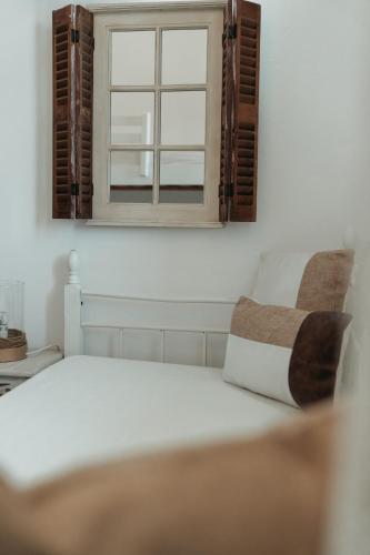 a bedroom with a white bed and a window at Astrio Suites in Livadion