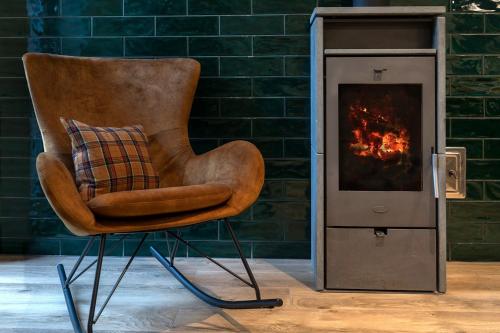 a chair with a pillow next to a fireplace at reBORONA in Őriszentpéter