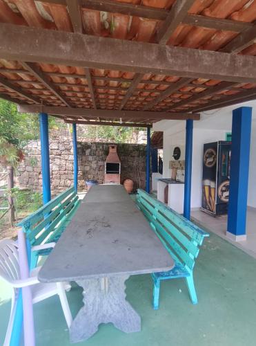 a table and two chairs sitting under a roof at Casa Paraíso Bananal - Iha Grande - Angra Dos Reis in Angra dos Reis