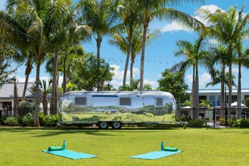 a green caravan parked in a field with trees at Blue Flamingo Resort Key West in Key West
