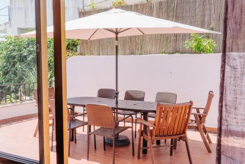 a table and chairs with an umbrella on a patio at Spacious seaside house in Cascais