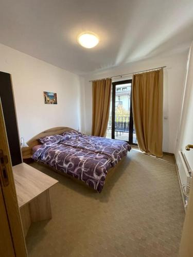 a bedroom with a bed and a large window at South Mountain Apartment in Razlog