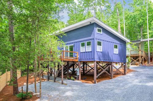 a blue house on a deck in the woods at Two Tree Houses - Galaxy & Full Bloom in Pittsboro