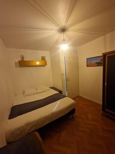 une chambre avec un lit et une lumière sur le mur dans l'établissement Le 11 un écrin dans Colmar, à Colmar