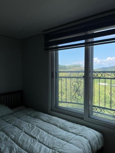 a bedroom with a bed and a large window at Incheon Intl Airport ANN Guest House in Incheon