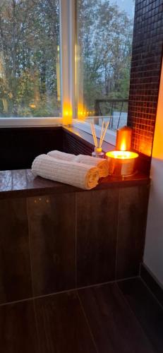 a bathroom with two candles and a towel and a window at Vila Roda in Banja Luka