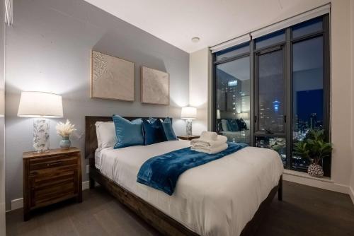 a bedroom with a large bed and a large window at Poolside Bliss w Rocky MTN & Tower Views - FREE Banff Pass, Outdoor Pool, Parking, Gym, & Wine! in Calgary