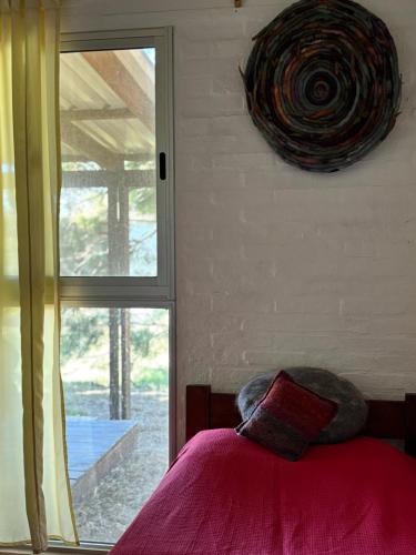 a bedroom with a bed with a pillow and a window at Monoambiente en Valizas in Barra de Valizas
