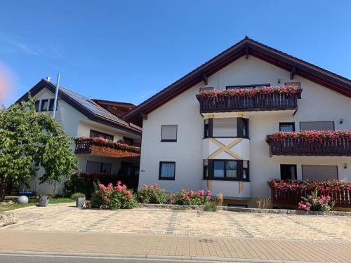 un edificio blanco con flores en las ventanas en Hudolin-Vermietungen, en Gundelsheim