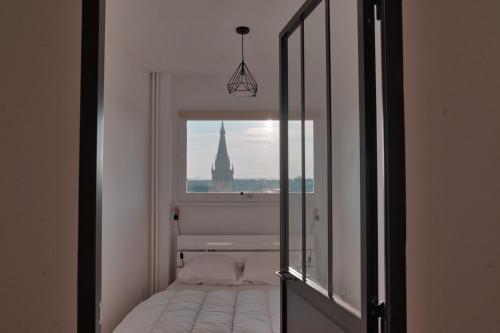 - une chambre avec un miroir et une vue sur un bâtiment dans l'établissement la terrasse du coislin, à Metz