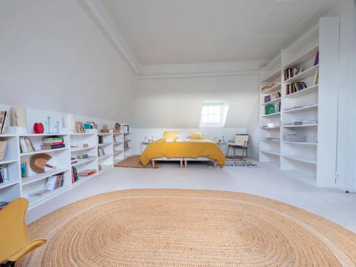 - une chambre avec un lit jaune et des étagères blanches dans l'établissement Maison Hestia - Collection Idylliq, à Épégard