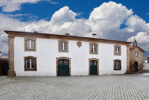 a large white building with two doors on it at Casa da Fidalga in Outeiro de Gatos