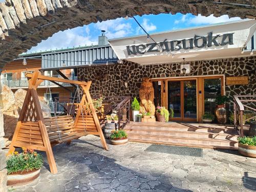 a restaurant with a wooden bench in front of a building at Štúdio Srnček - Tatranská Štrba - wellness, bazén in Štrba