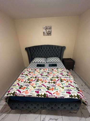 a bed with a floral quilt on it in a bedroom at Masion belle vue in Sarcelles