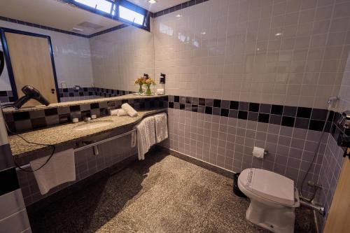 a bathroom with a toilet and a sink and a mirror at South American Copacabana Hotel in Rio de Janeiro